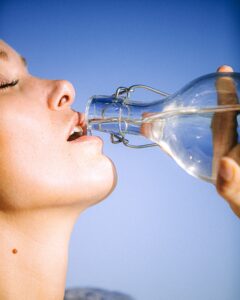 mujer tomando agua de una botella